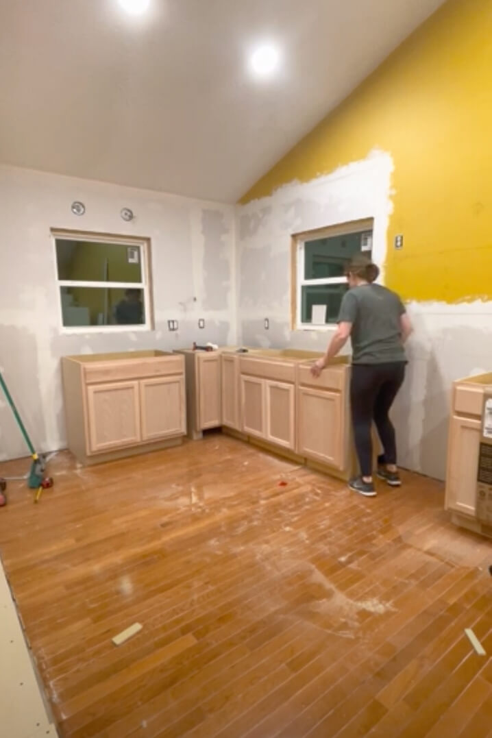 Installing base cabinets in a DIY kitchen remodel.